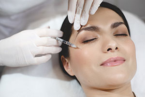 Young woman lying with closed eyes during botox