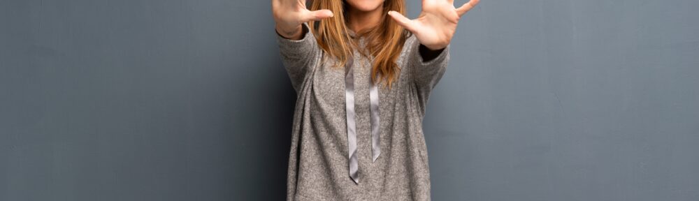 Blonde woman over grey background counting ten with fingers