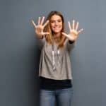 Blonde woman over grey background counting ten with fingers